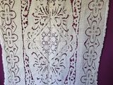 a white lace curtain hanging on a purple wall