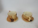 two cups and saucers sitting on a white table