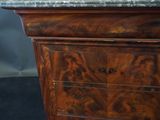 a wooden cabinet with a marble top in a room