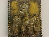 une image représentant une plaque métallique sur laquelle figure un oiseau