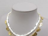 necklace with gold coins and pearls on a white mannequin