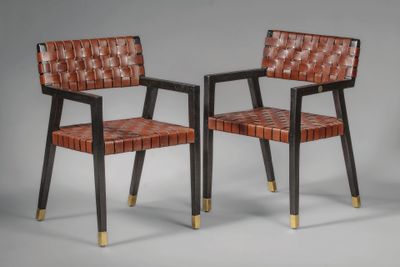 une paire de fauteuils en cuir avec des pieds en laiton et une assise tressée