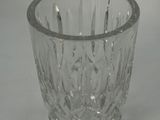 a clear glass cup with a silver rim on a white surface