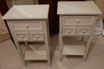 deux tables de chevet blanches avec des tiroirs, placées de chaque côté