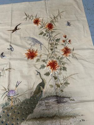 une image représentant une nappe ornée d'un paon et de fleurs