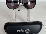 une paire de lunettes de soleil Polarvitee dans un étui noir posé sur une surface blanche