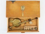 a wooden box with various items in it on a white surface