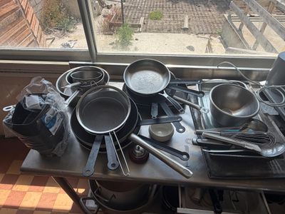 many pots and pans on the table by the window
