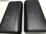 the back and side of a black power bank sitting on top of a white table