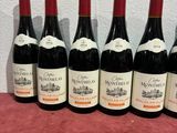 six bottles of wine are lined up on a table