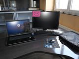 un ordinateur portable posé sur un bureau, à côté d'un écran d'ordinateur