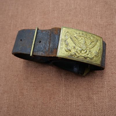 une vieille ceinture avec une boucle en laiton sur un fond marron
