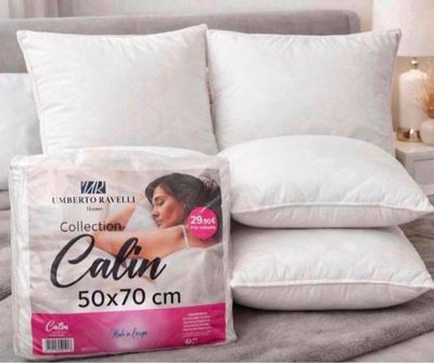 deux oreillers sur un lit, avec un oreiller posé dessus