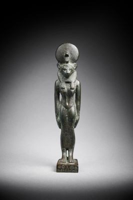 an egyptian bronze statue of a woman with a hat on her head