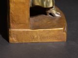 bronze statue of a man sitting on a bench with his feet crossed