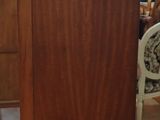 a tall wooden cabinet in the middle of a room