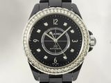 un gros plan d'une montre noire dotée d'une lunette sertie de diamants