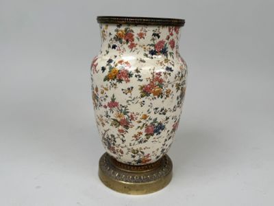 un vase posé sur un support sur une surface blanche