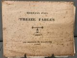 un vieux livre posé sur une table en bois, près d'un mur gris