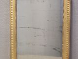 a picture of a gold framed mirror sitting on a table