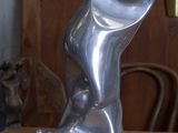 une sculpture en argent posée sur une table en bois dans une pièce