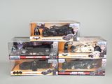 three batman action figures and a batmobile in a display case