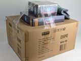 a stack of books wrapped in plastic on top of a cardboard box