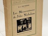 un vieux livre posé sur une table à côté d'un mur blanc