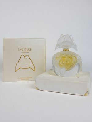 une image représentant un flacon de parfum posé sur une boîte