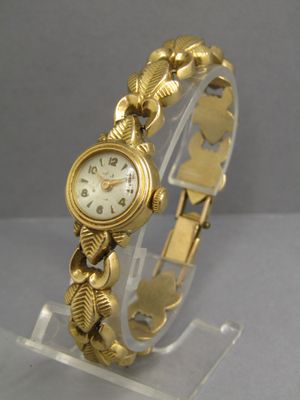 an image of a close up of a wrist watch on a clear stand
