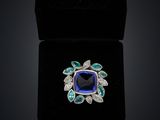 a blue sapphire and diamond ring in a black velvet box