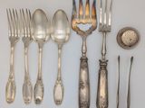 a lot of silver spoons and forks on the table