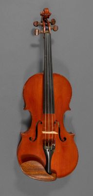 an old violin hanging on a wall with a wooden stand