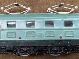 a green toy train on a brown carpeted floor