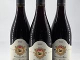trois bouteilles de vin posées sur une table blanche
