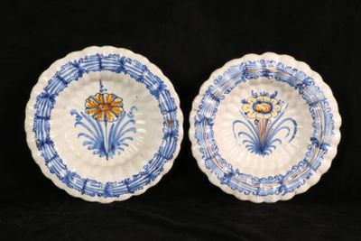two blue and white plates with flowers on them on a black background