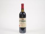 une bouteille de vin rouge posée sur une table blanche