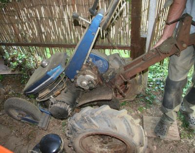 un homme debout à côté d'un tracteur équipé d'une charrue