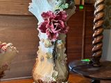 two vases sitting on a table with flowers on them