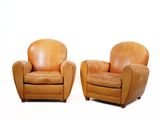 deux chaises en cuir marron assises l'une à côté de l'autre sur une surface blanche