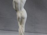 statue of a woman standing on a pedestal with her back to the camera