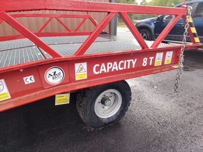 une remorque à plateau rouge équipée d'une grue
