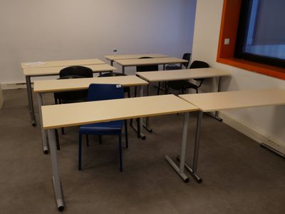 many tables and chairs in a room with a large window