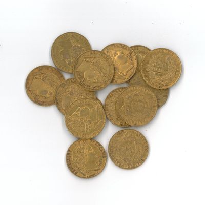 quelques pièces d'or sont éparpillées les unes à côté des autres sur une surface blanche