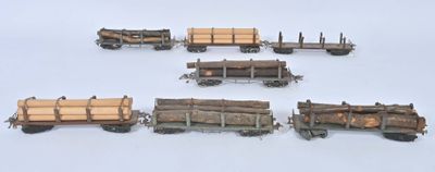 six wagons en bois chargés de grumes, posés sur une surface blanche