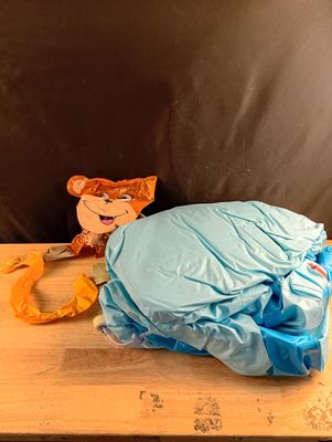 a stuffed animal that is sitting on a table next to a bag