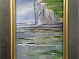 painting of a painting of a cliff and a body of water in a gold frame