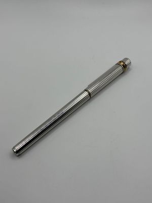 un stylo à bille argenté posé sur une table blanche