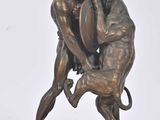 statue en bronze représentant un homme aux prises avec un chien, posée sur un socle en marbre