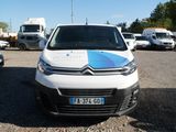 a white van with a blue and white stripe parked in a parking lot